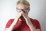 Exhausted mature man rubbing nose bridge after wearing 3974777
