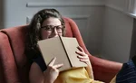Woman in brown framed eyeglasses holding a book 3978402