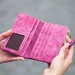 Person holding pink suede long waller 910122